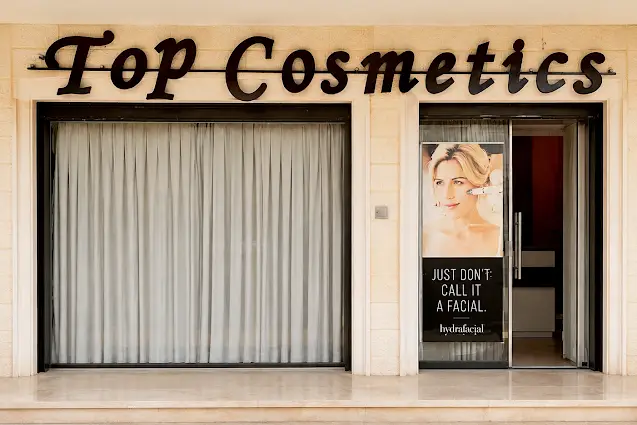 واجهة عيادة Top Cosmetics مع لافتة المدخل